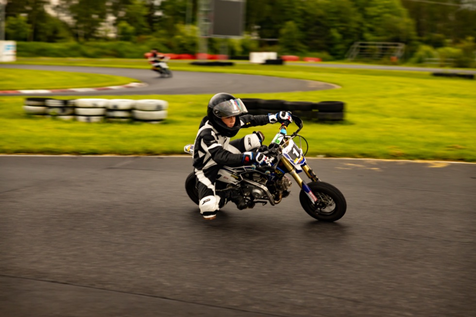 Junger Fahrer in Schräglage beim Pitbike-Training