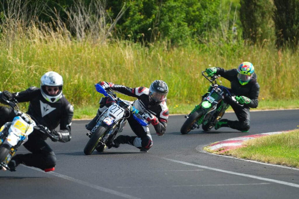 Drei Pitbike-Fahrer auf Outdoor-Rennstrecke beim Track-Day Training